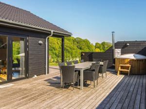 a wooden deck with a table and chairs on it at 5 star holiday home in Haderslev in Haderslev