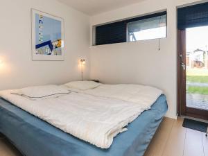 a bed in a room with a large window at 4 person holiday home in Bogense-By Traum in Bogense