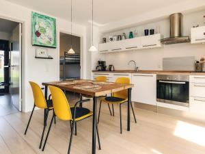 a kitchen with a wooden table and yellow chairs at 4 person holiday home in Bogense-By Traum in Bogense +34 photos
