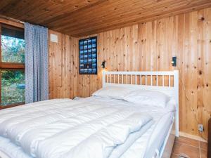 a large white bed in a room with wooden walls at 7 person holiday home in Kolind in Kolind