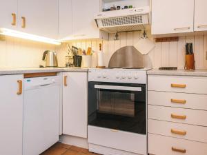a kitchen with white cabinets and an oven at 7 person holiday home in Kolind in Kolind