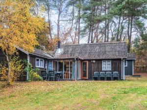 a house with a porch and chairs in the yard at 7 person holiday home in Kolind in Kolind +29 photos