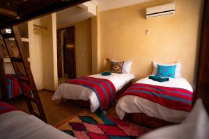 a bedroom with two bunk beds and a ladder at Wave chaser surfhouse morocco in Agadir