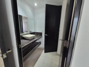 a bathroom with a black door and a sink at Modern apartment Altravia 6 tower in Cholula +14 photos