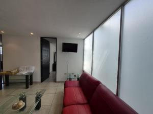 a living room with a red couch and a table at Modern apartment Altravia 6 tower in Cholula