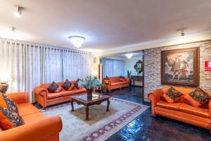 a living room with orange couches and a table at Hotel Agustos Cusco in Cusco +60 photos