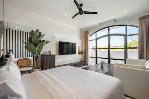 a bedroom with a white bed and a large window at Avida Studios in Uluwatu - 5 mins walk to Thomas Beach in Uluwatu
