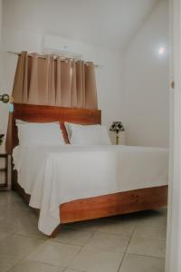 a bedroom with a large bed with white sheets at Villa La Dueña Las Terrenas in Las Terrenas +30 photos