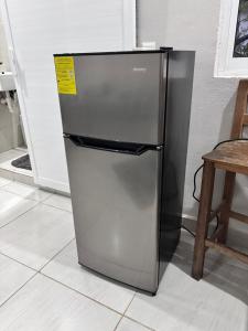 a stainless steel refrigerator with a yellow tag on it at La Isla Studio - Quimixto in Qumiste