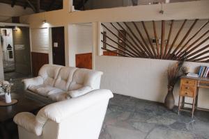 a living room with white leather couches and a table at Casa Calamo Hotel in Treinta y Tres