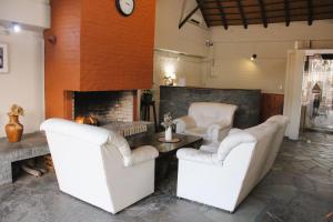 a living room with two chairs and a fireplace at Casa Calamo Hotel in Treinta y Tres