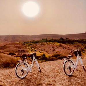 two bikes parked on a hill with the sun in the background at villa Oasis Rouge Sable in Marrakesh