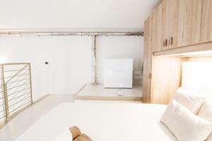 ミラノにあるAlessia's Flat - Mac Mahonのベッドルーム(白いベッド1台、冷蔵庫付)