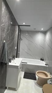 a bathroom with a tub and a toilet and a sink at Urban Berazategui in Berazategui +8 photos