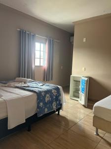 a bedroom with a large bed and a window at Hospedagem Riazo in Pirenópolis