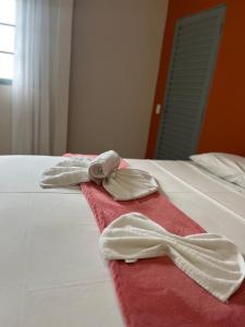 a pair of towels sitting on top of a bed at Hospedagem Riazo in Pirenópolis