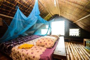 ein Bett in einem Zimmer mit einem Moskitonetz in der Unterkunft Escape3points in Cape Three Points