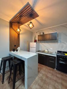 a kitchen with a large white counter and black cabinets at Urban Berazategui in Berazategui