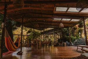 a patio with a hammock and tables and chairs at ONDA Boquete in Boquete