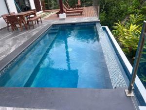 a swimming pool with blue water in a yard at Modern Villa Overlooking Macal River Valley in Benque Viejo del Carmen +6 photos