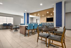 a dining room with tables and chairs and a tv at Holiday Inn Express Marble Falls by IHG in Marble Falls