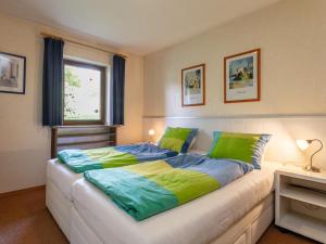 a bedroom with a large bed with green and blue sheets at Amberg in Schwoich