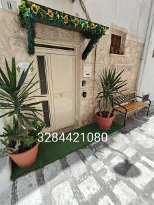 a door with two plants and a bench next to it at Tama67 suite in Ostuni