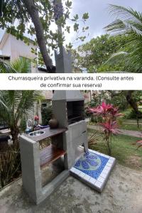 a stone stove with a sink in a garden at Cond Vista Hermosa - Casas para famílias 2 quartos in Pipa