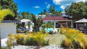 a house with a swimming pool and palm trees at Villa La Dueña Las Terrenas in Las Terrenas