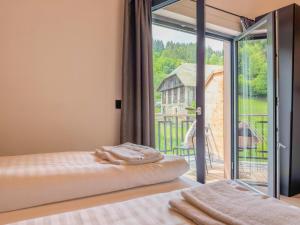 a bedroom with two beds and a large window at Obermöschach 1B in Lake Pressegg