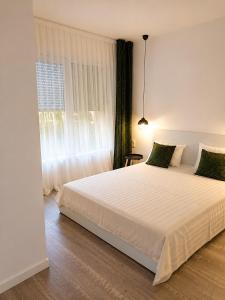 a bedroom with a large white bed and a window at Vila Dar Selam halal-friendly in Mostar