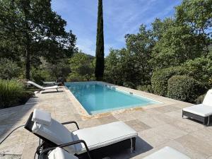 a swimming pool with two lounge chairs at Le Serre des Granges in Montaulieu