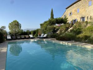 a swimming pool in front of a building at Le Serre des Granges in Montaulieu +18 photos