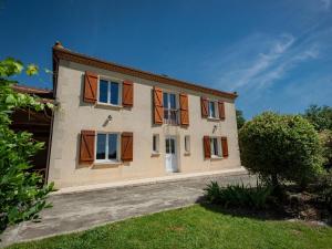 a house with wooden shutters on the side of it at Grande Gite Bassoues in Bassoues