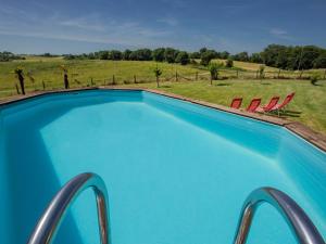 a swimming pool with chairs and a view of a field at Grande Gite Bassoues in Bassoues
