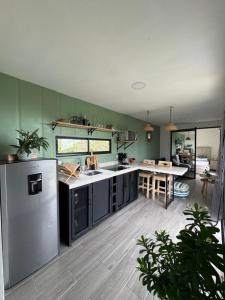 a kitchen with a refrigerator and a table in it at Kèbi Container Home near Blue Falls in Colonia