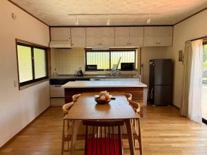 a kitchen with a table and a kitchen with a refrigerator at Kia Ora Setouchi in Shodoshima