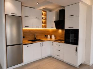 a kitchen with white cabinets and a refrigerator at Vila Dar Selam halal-friendly in Mostar