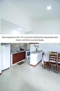 a living room with a table and a kitchen at Lovely Pipa in Pipa