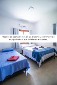 two beds in a room with blue sheets at Lovely Pipa in Pipa