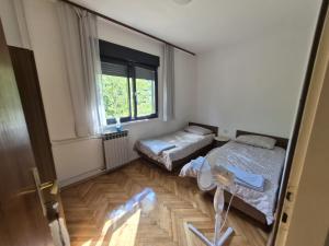 two beds in a room with a window at Apartments with parking space Moscenicka Draga, Opatija - 2346 in Mošćenička Draga