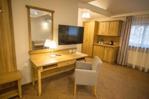 a room with a desk with a television and a chair at Hotel i Restauracja Pod Szyszkami in Krotoszyn