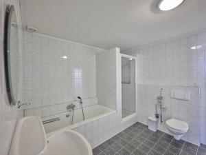 a bathroom with a tub and a toilet and a shower at De open schuur in Elsendorp +57 photos