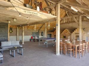 a large living room with tables and a ping pong table at De open schuur in Elsendorp