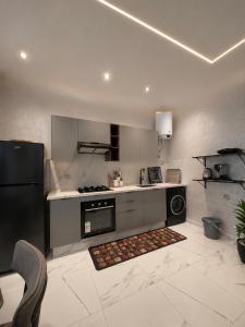 a kitchen with a black refrigerator and a stove at Mehdia plage in Kenitra