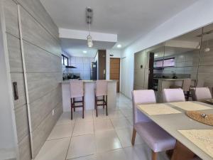 a kitchen and dining room with a table and chairs at Apartamento com suite in Parnamirim