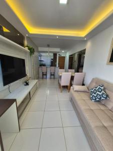 a living room with a couch and a flat screen tv at Apartamento com suite in Parnamirim +8 photos