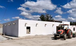 a tractor parked in front of a white building at Tu hostalito en Parras in Santa Isabel