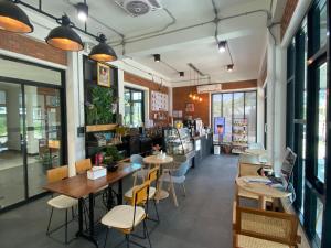 a restaurant with tables and chairs and windows at The Connect Chiang Mai in Chiang Mai