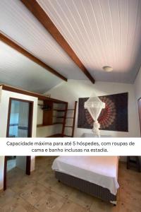 a room with a ceiling with a bed and a picture at Chalé Kamala com quintal - Perfeito para Nômades Digitais in Pipa
